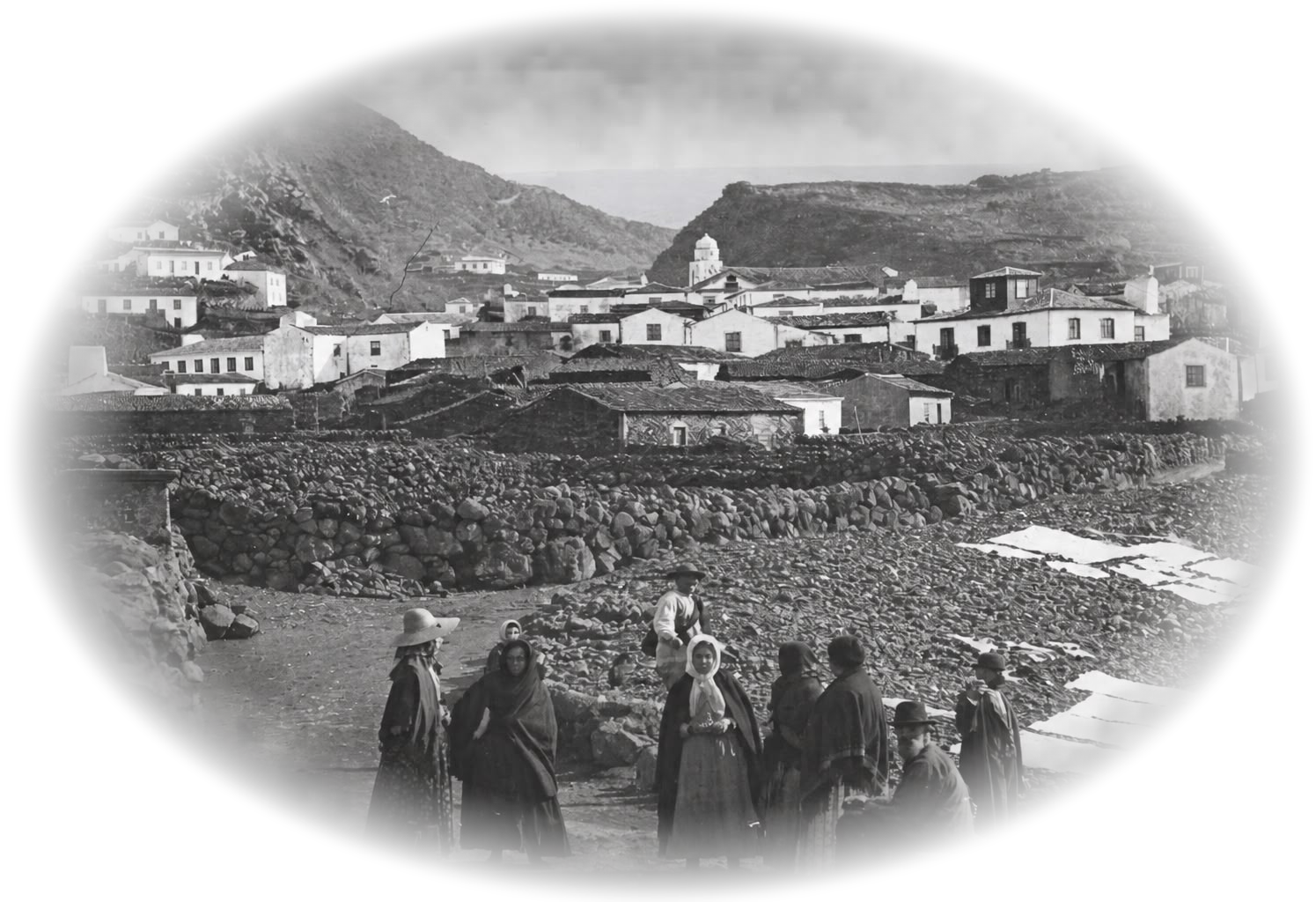 Fotografia histórica de uma vila baleeira açoriana, com mulheres em primeiro plano